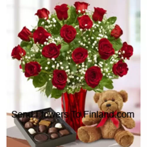 25 Rosas rojas con algunos helechos en un jarrón de vidrio, un lindo osito de peluche marrón y una caja de chocolates importados