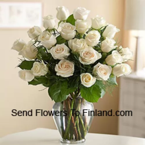 25 roses blanches avec quelques fougères dans un vase en verre