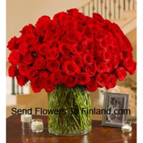 101 rote Rosen mit etwas Farn in einer großen Glasvase